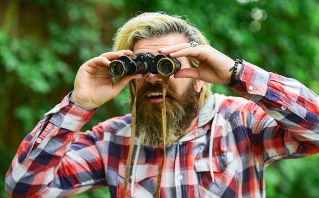 Você pode ver esse conceito de viagem olhando para longe no futuro hobby e relaxa o homem de turistas com binóculos Procurando algo ao longo da floresta homem com telescópio de binóculos na floresta