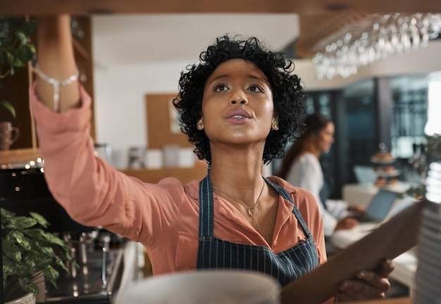 Foto você tem que fazer pequenas coisas para conseguir grandes coisas foto de uma mulher contando estoque enquanto trabalha em um café