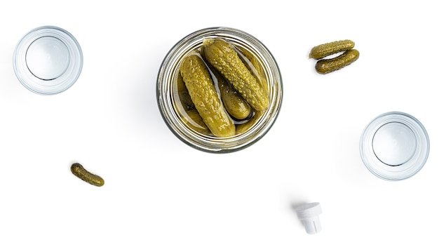 Vodka, copos e pickles em um fundo branco