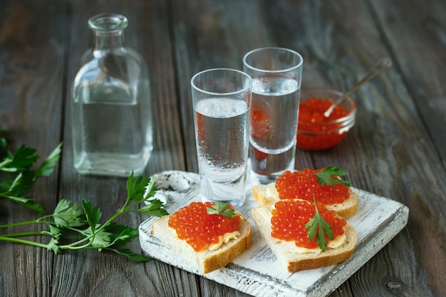 Vodka e petisco tradicional em fundo de madeira