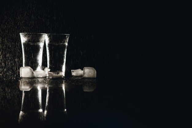 Vodka. fotos, copos com vodka com gelo. fundo escuro. copie o espaço. foco seletivo