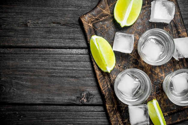 Vodka con hielo en una tabla para cortar con rodajas de limón