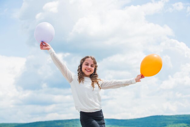 Voe com balões de hélio Cada vez mais alto todos os dias Menina alegre divirta-se Conceito de liberdade A felicidade é balões de ar Férias e férias de verão Felicidade da infância Conceito de felicidade