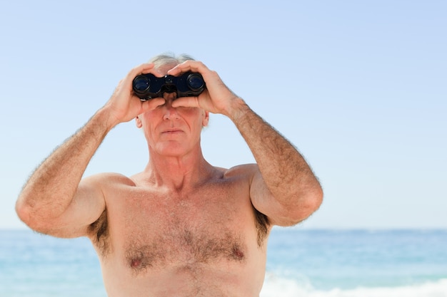 Vogel des älteren Mannes, der am Strand aufpasst