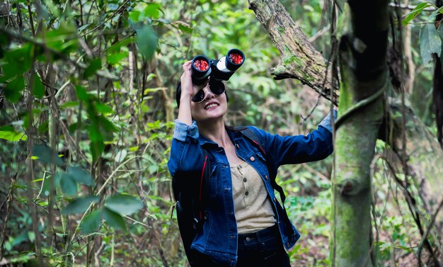 Vogelbeobachtung im Wald mit natürlichem Hintergrund. Tourist mit Fernglas. Outdoor-Aktivität und Erholung im Sommerurlaub.