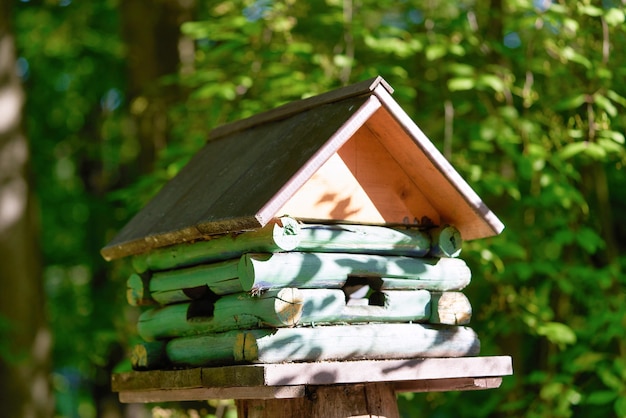 Vogelhaus aus Holz in Form eines Hauses auf einem Baumstumpf im Park