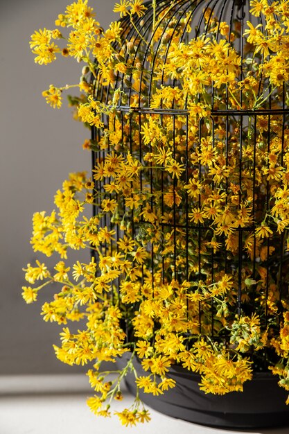 Vogelkäfig mit gelben Blumen für Wohnkultur