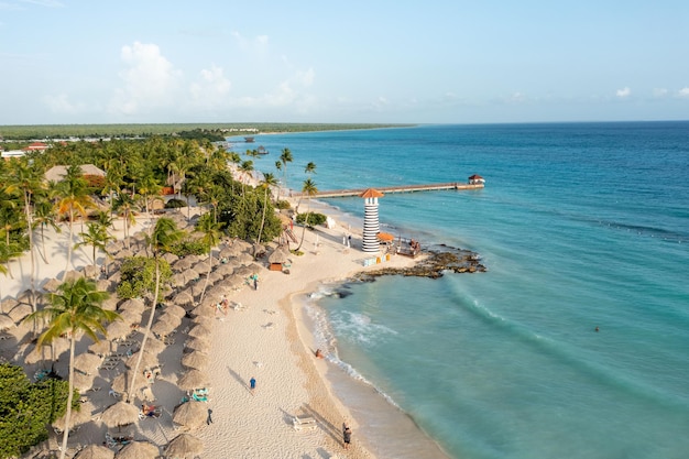 Vogelperspektive auf einen Strand mit Palmen und einem Leuchtturm in der Dominikanischen Republik