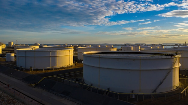 Vogelperspektive des Tanklagers mit vielen Öltank und petrochemischem Sammelbehälter bei Sonnenuntergang, industrielle Tanklagervogelperspektive.