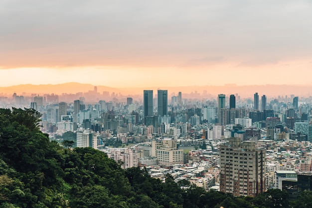 Vogelperspektive über im Stadtzentrum gelegenem Taipeh mit Schichten Berg im Hintergrund in der Dämmerung vom Xiangshan-Elefantenberg am Abend.