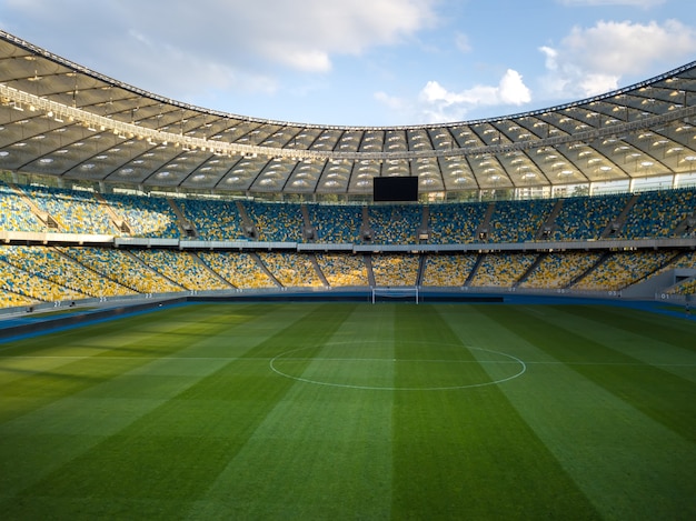 Vogelperspektive von blau-gelben Drohnenständen und einem grünen Feldstadion an einem Sommertag gegen einen blauen Himmel.