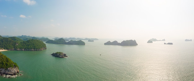 Vogelperspektive von langer bucht ha von cat ba-insel, berühmter tourismusbestimmungsort in vietnam. szenischer blauer himmel mit wolken, kalksteinfelsenspitzen im meer am horizont.