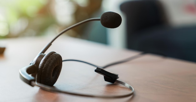 VOIP-Headset des Telefonisten des Kundensupports am Arbeitsplatz auf dem Schreibtisch.