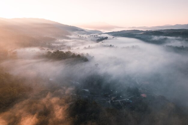 Volando por encima del amanecer y la niebla de las nubes, en la colina