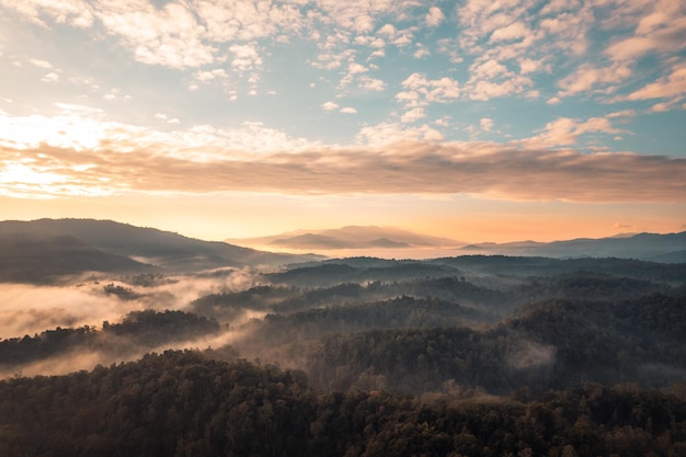 Volando por encima del amanecer y la niebla de las nubes, en la colina