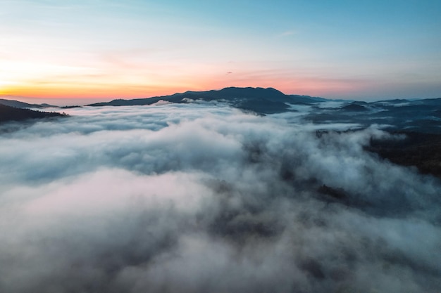 Volando por encima del amanecer y la niebla de las nubes, en la colina