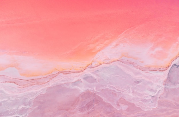 Volando sobre un lago salado rosa Instalaciones de producción de sal Campos de estanques de evaporación salina en el lago salado Dunaliella salina imparte un agua rosa roja en un lago mineral con costa salada cristalizada seca