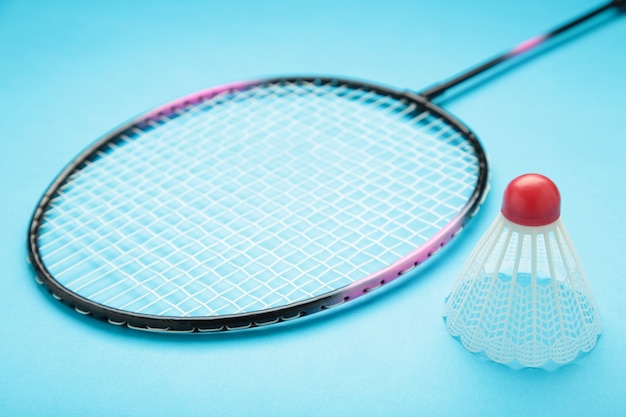 Volantes e raquete de badminton isoladas em azul