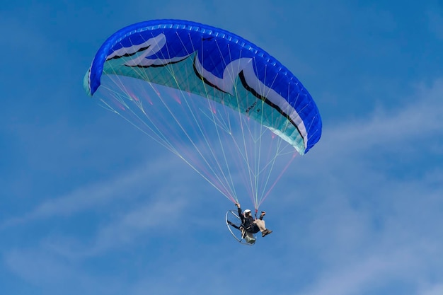 Volar con paramotor en el aire sobre fondo de cielo azul