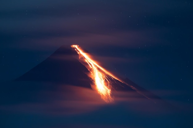 Foto volcán en erupción por la noche arrojando lava