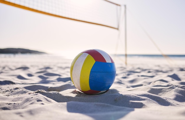 Vôlei de praia e areia com fundo de oceano e mar com esporte de exercício e equipamentos de ginástica Verão ao ar livre e bola de treinamento no chão para jogo de saúde e atividade de treino na natureza