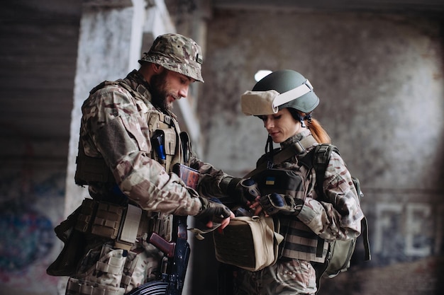 Voll ausgestattete und bewaffnete ukrainische Soldaten, die ihre Ausrüstung überprüfen, während sie eine Pause machenxA