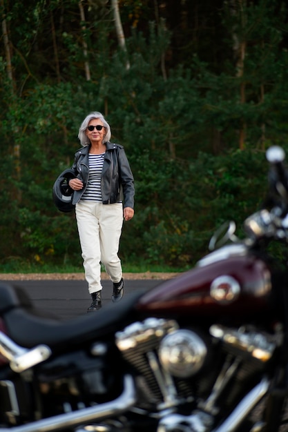 Vollbildaufnahme einer älteren Frau mit Motorrad