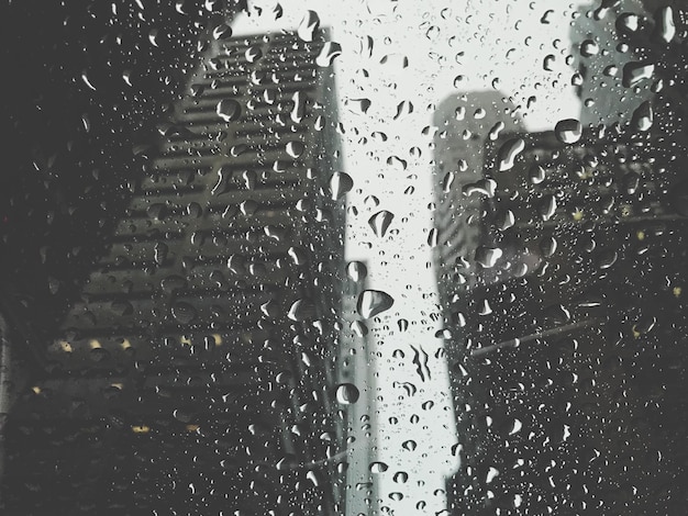 Vollbildaufnahme von Regentropfen auf Glasfenster