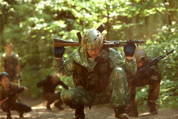 Volle militärische Erfahrung Ein Tageskommando, das mit einer automatischen Gewehrreplik durch das Wasser läuft