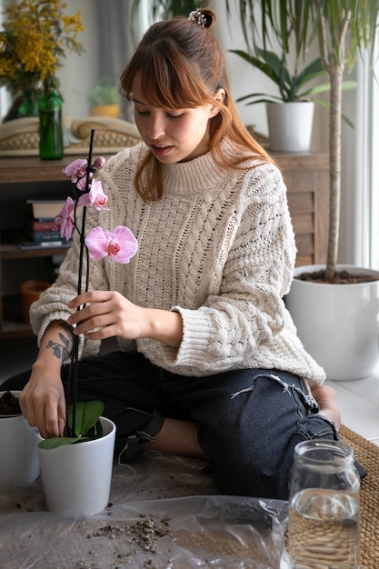 Foto volle schussfrau mit schöner orchidee