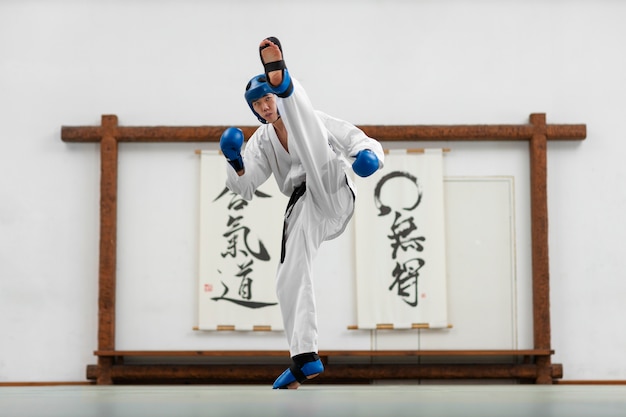 Voller Schuss asiatischer Mann, der Taekwondo übt