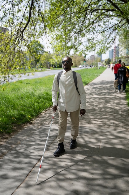 Foto voller schuss blinder, der im park spazieren geht