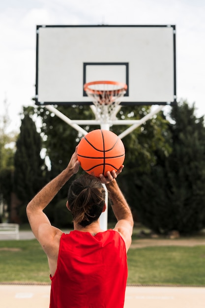 Foto voller schuss des jungen, der in den basketballkorb wirft