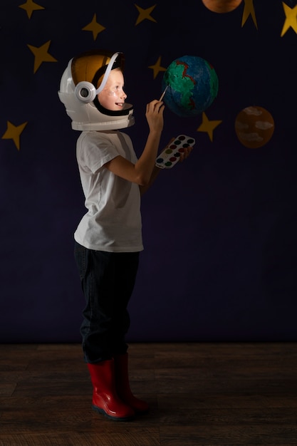 Voller Schuss Smiley-Kind malt Planeten