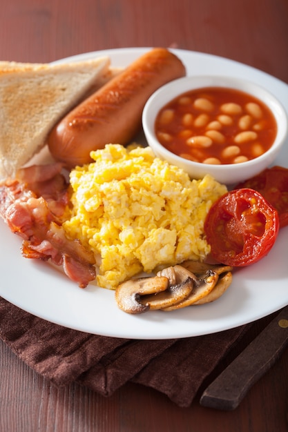 Volles englisches Frühstück mit Rührei, Speck, Wurst, Bohnen, Tomate