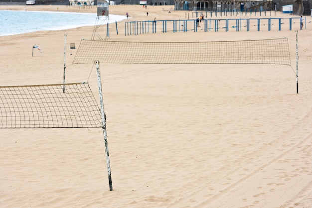 Volleyballnetz auf einem Sandstrand durch das Meer