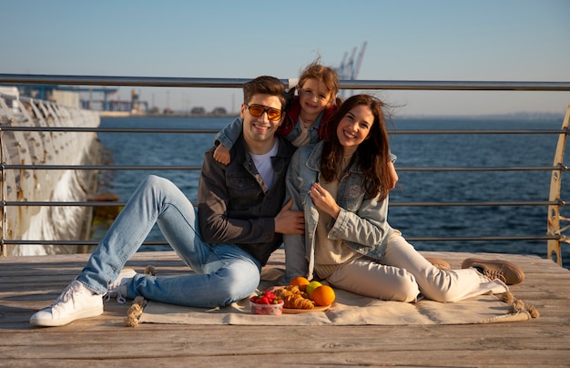 Vollfotografierte Familie, die auf einem Steg herumhängt