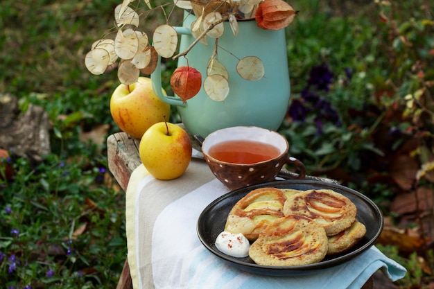 Vollkorn-Apfelpfannkuchen serviert mit Tee im rustikalen Garten