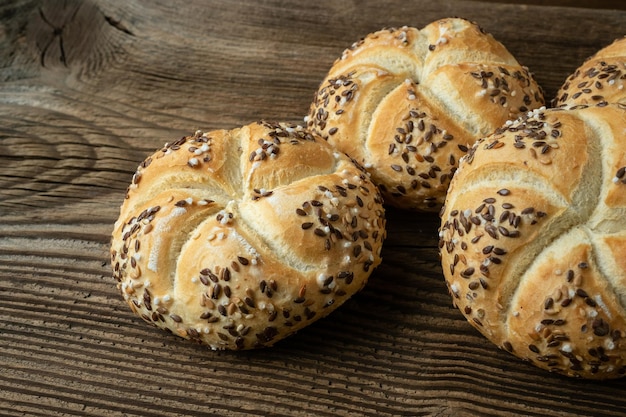 Vollkornbrot auf Holzhintergrund Bündel Kaiserbrötchen mit Sesam