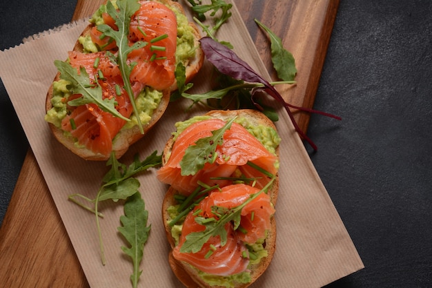 Vollkornbrot mit Avocadopaste und Lachs, Rucolablätter.