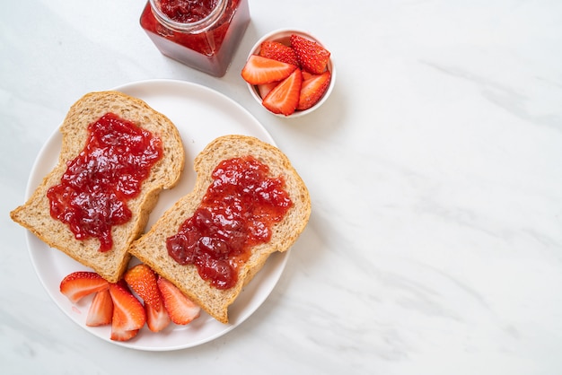 Vollkornbrot mit Erdbeermarmelade und frischer Erdbeere