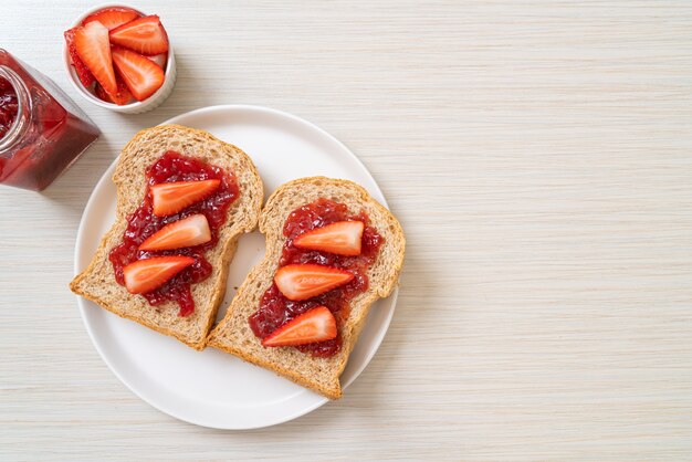 Vollkornbrot mit Erdbeermarmelade und frischer Erdbeere