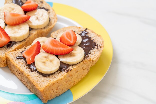 Vollkornbrot mit frischer Banane, Erdbeere und Schokolade zum Frühstück geröstet