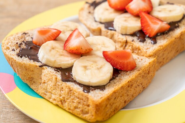 Vollkornbrot mit frischer Banane, Erdbeere und Schokolade zum Frühstück geröstet