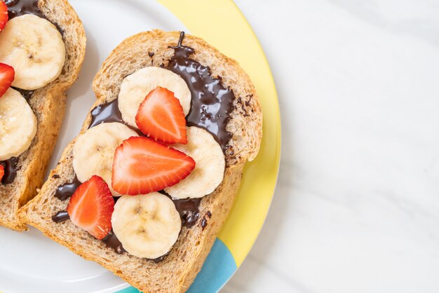 Vollkornbrot mit frischer Banane, Erdbeere und Schokolade