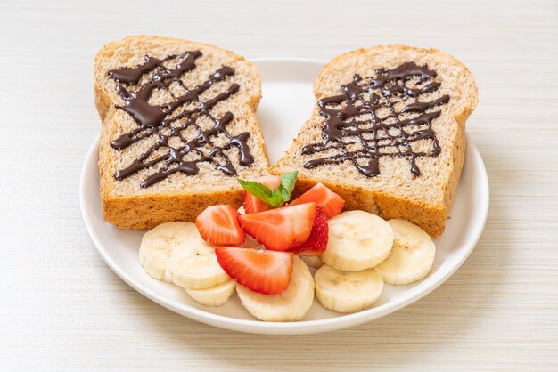 Vollkornbrot mit frischer Banane, Erdbeere und Schokolade