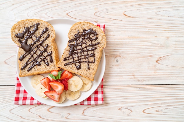 Vollkornbrot mit frischer Banane, Erdbeere und Schokolade