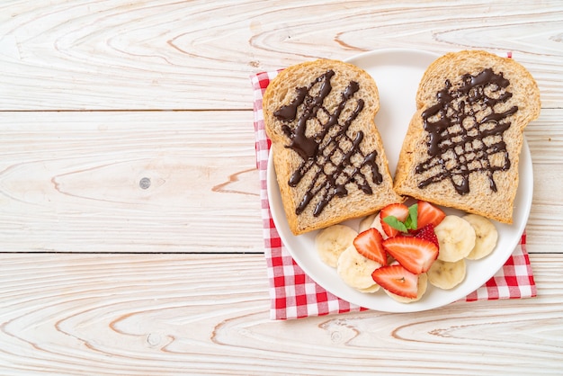 Vollkornbrot mit frischer Banane, Erdbeere und Schokolade