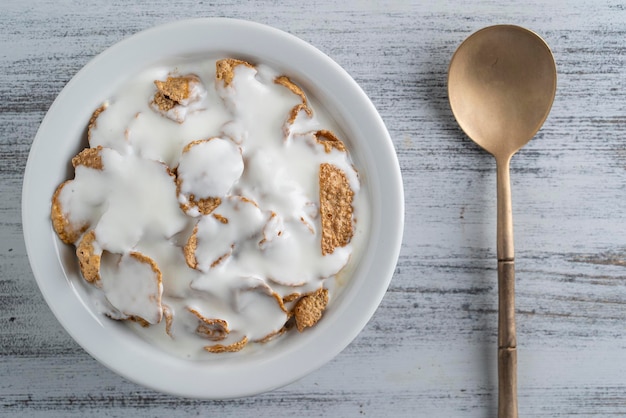 Vollkornglasierte Flocken mit Joghurt in der Platte Gesundes Frühstück Vollkornmüsli in einer Schüssel