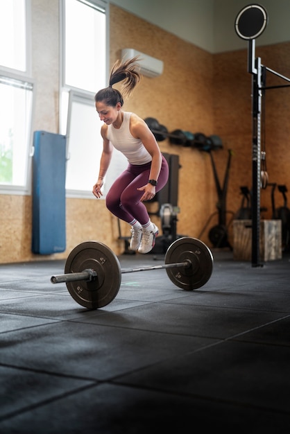 Foto vollschussfrau, die im fitnessstudio springt